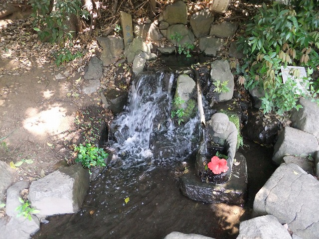唯物園 自然井：湧き水の湧きでた泉にお坊さんがいます。